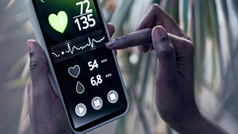 Woman checking pulse trace through mobile phone at home