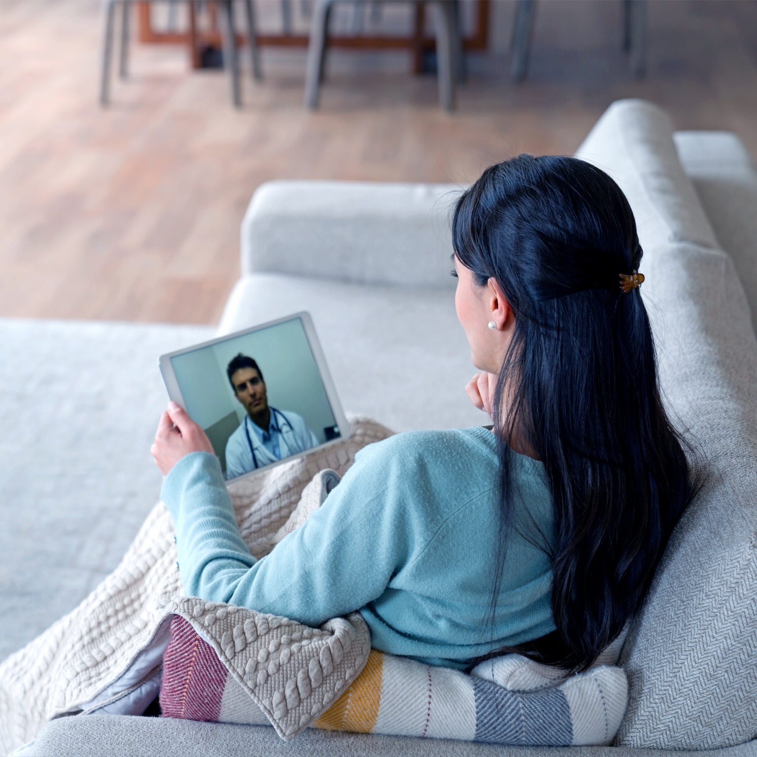 Woman at home feeling poorly and talking to her doctor on a video call