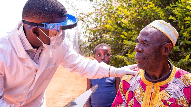 African doctor conversing with an elderly patient during a medical examination