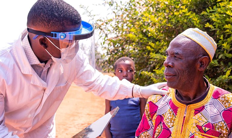 African doctor conversing with an elderly patient during a medical examination