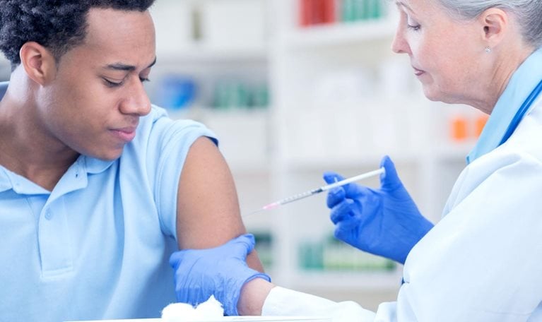 Photo of a man being vaccinated at a pharmacy.