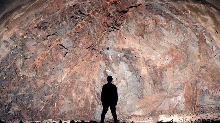 Mine, tunnel front, silhouette of a standing worker