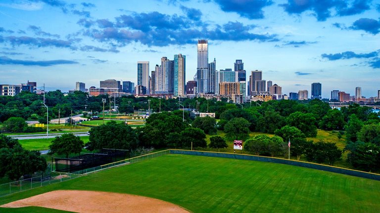 Wide angle view of the skyline with tall towers and green grass and a walkway