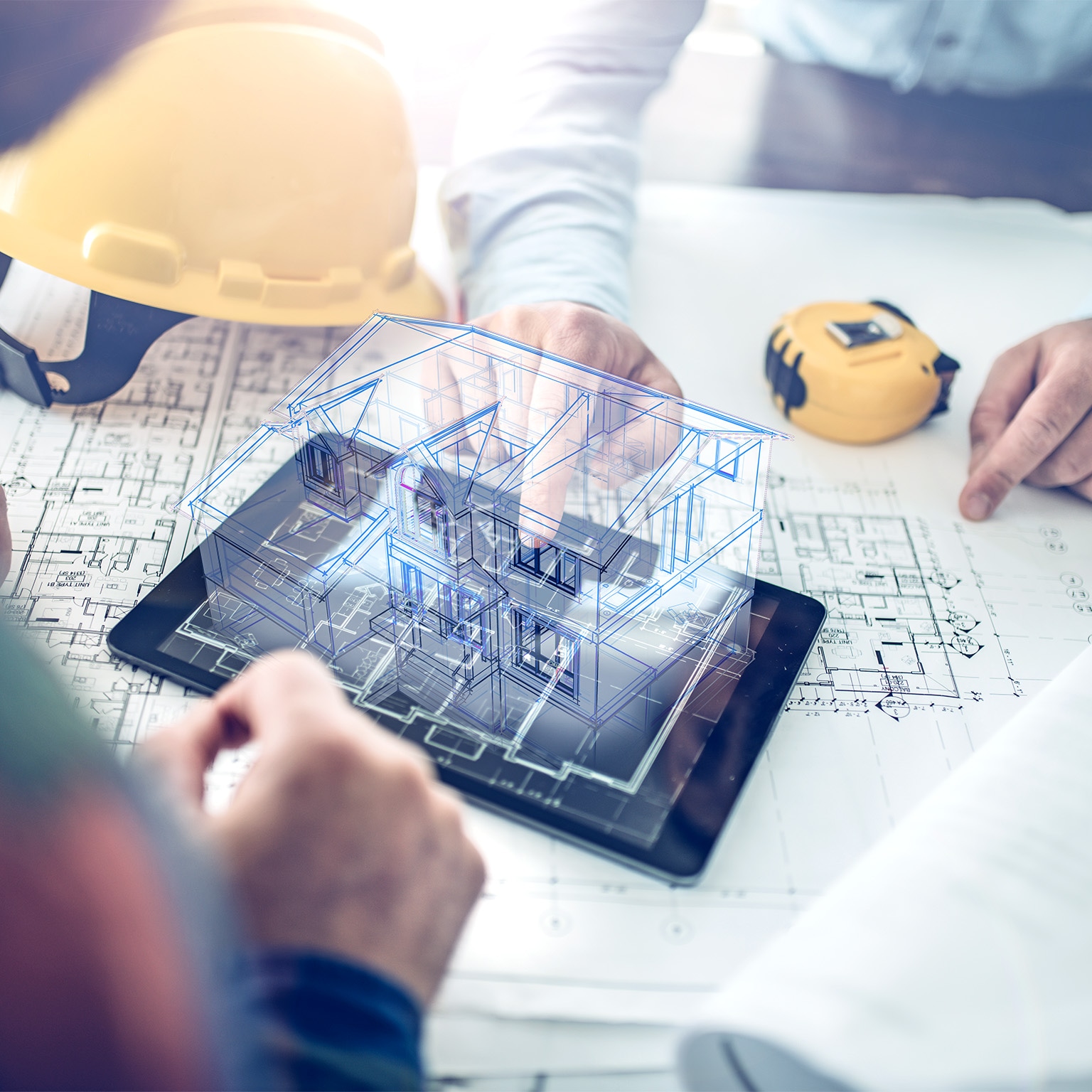 Architect and a client looking at the hologram of a building project projected over a tablet computer.