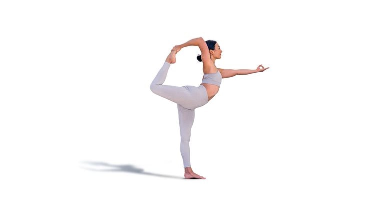 Brunette woman in sportswear doing the Natarajasana pose or dancer's pose