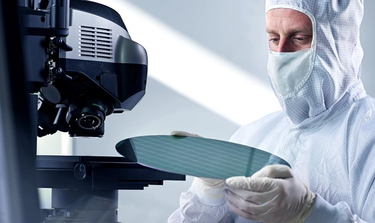 Engineer putting wafer chip on microscope in laboratory