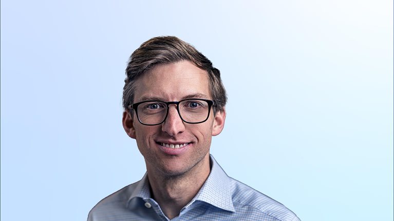 Chris Miller in a light blue shirt against a light blue background
