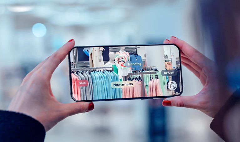 Female hand holding smartphone using augmented reality application to check special sale price in retail fashion store.