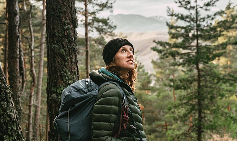 Woman looking at the forest while hiking - stock photo