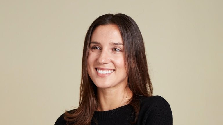 A smiling Nan Ransohoff photographed against a tan wall.