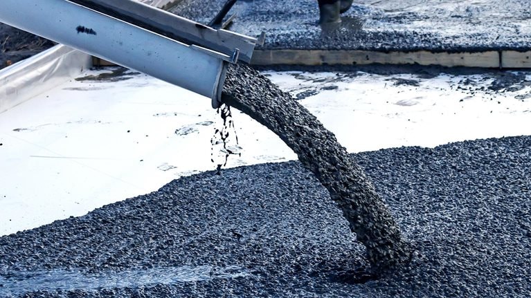 Image of a mobile concrete mixer being used to pour the foundation for construction of a residential building.