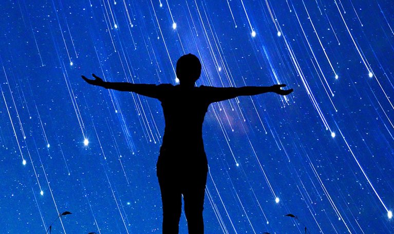 A girl standing with her arms open to a sky full of shooting stars